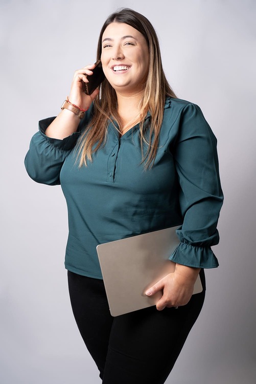 Reportage corporate: Une dame est au téléphone et elle tient son ordinateur portable