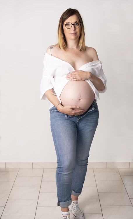 Photographie de grossesse: Une Dame pose dans son salon. Photographie en lifestyle